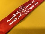 Red polyester tie-back headband featuring the emblem and Arabic script of the National Resistance Brigades, Martyr Omar Al-Qassem Forces, affiliated with the Democratic Front for the Liberation of Palestine (DFLP).