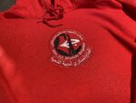 Abu Ali Mustafa Brigades hoodie, PFLP military wing hoodie, red militant symbol hoodie, resistance movement apparel, Palestinian revolutionary hoodie, Middle Eastern militant emblem clothing, Popular Front for the Liberation of Palestine, red embroidered logo hoodie, political statement streetwear, كتيبة الشهيد أبو علي مصطفى, الجبهة الشعبية لتحرير فلسطين, زي المقاومة الفلسطينية, سترة بغطاء رأس بشعار مقاوم, ملابس الجبهة الشعبية, collector’s edition, militant-inspired fashion, PFLP hoodie.