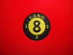 Embroidered round CJNG eight ball patch with black background, yellow “8” center, “C.J.N.G.” at the top, and the numbers 1, 2, and 3 stitched around the outer edge, displayed on a red fabric background.