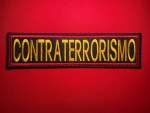 CONTRATERRORISMO Counter-Terrorism Vest Patch (9.5 x 2.5 inches) Embroidered CONTRATERRORISMO rectangular patch with gold lettering on black background and red satin border, photographed on red fabric background.