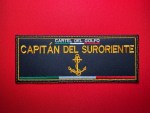 Black embroidered “Capitán del Suroriente” Cártel del Golfo vest patch with gold lettering, anchor emblem, and Mexican tricolor stripe, displayed on a red background.