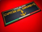 Black embroidered “Capitán del Suroriente” Cártel del Golfo vest patch with gold lettering, anchor emblem, and Mexican tricolor stripe, displayed on a red background.