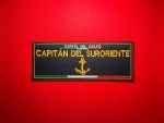 Black embroidered “Capitán del Suroriente” Cártel del Golfo vest patch with gold lettering, anchor emblem, and Mexican tricolor stripe, displayed on a red background.