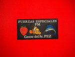 Rectangular black patch reading “FUERZAS ESPECIALES” and “FM” with “Gente del Sr. PEZ” below, featuring a strawberry, a clownfish, and a marlin icon in the center.