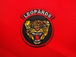 Haitian Corps des Léopards patch with snarling leopard head, integrated LEOPARDS rocker, black background and red border Duvalier era insignia