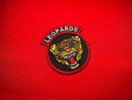Haitian Corps des Léopards patch with snarling leopard head, integrated LEOPARDS rocker, black background and red border Duvalier era insignia