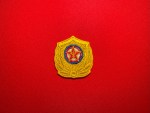 North Korean Ministry of Social Security embroidered tactical helmet badge patch with gold shield, grain wreath, red star and Workers’ Party emblem on a red background.