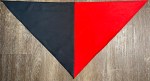 Red and black triangular revolutionary neckerchief laid flat showing half\-red half\-black design and finished edges