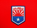 Front view of a reproduction KNLA Karen National Liberation Army Military Headquarters patch with S’gaw Karen lettering, red-and-white rising sun design, blue lower field, and white star.
