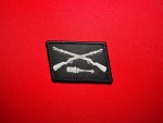 Black reproduction Dirlewanger collar tab featuring light gray crossed rifles above a horizontal stick grenade.
