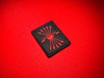 Angled close-up of a black Spanish Falange replica patch with a red embroidered yoke and five arrows emblem.