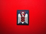 Reproduction Spanish Falanges Juveniles de Franco embroidered patch featuring a white swan, red-and-black checkered shield, and red yoke and arrows on dark blue fabric.