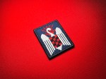 Reproduction Spanish Falanges Juveniles de Franco embroidered patch featuring a white swan, red-and-black checkered shield, and red yoke and arrows on dark blue fabric.
