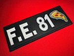 Angled view of a 9 × 3.5-inch F.E. 81 La Chapiza reproduction patch with white embroidered lettering and a pepperoni pizza emblem on black, displayed on red fabric.