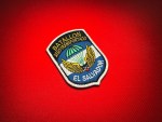 Angled view of the El Salvador Airborne Battalion embroidered replica patch, showing its parachute-and-wings design, stitched lettering and white satin border.